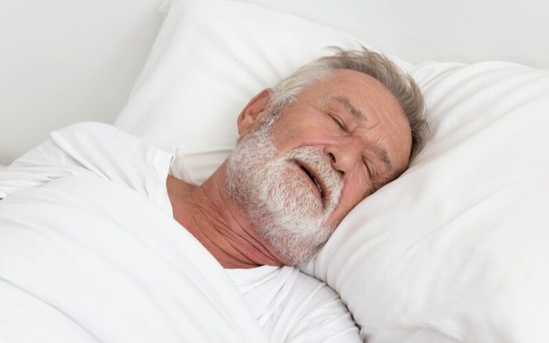 old man sleeping on bed