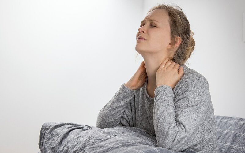 sick woman bed touching her neck suffering from pain